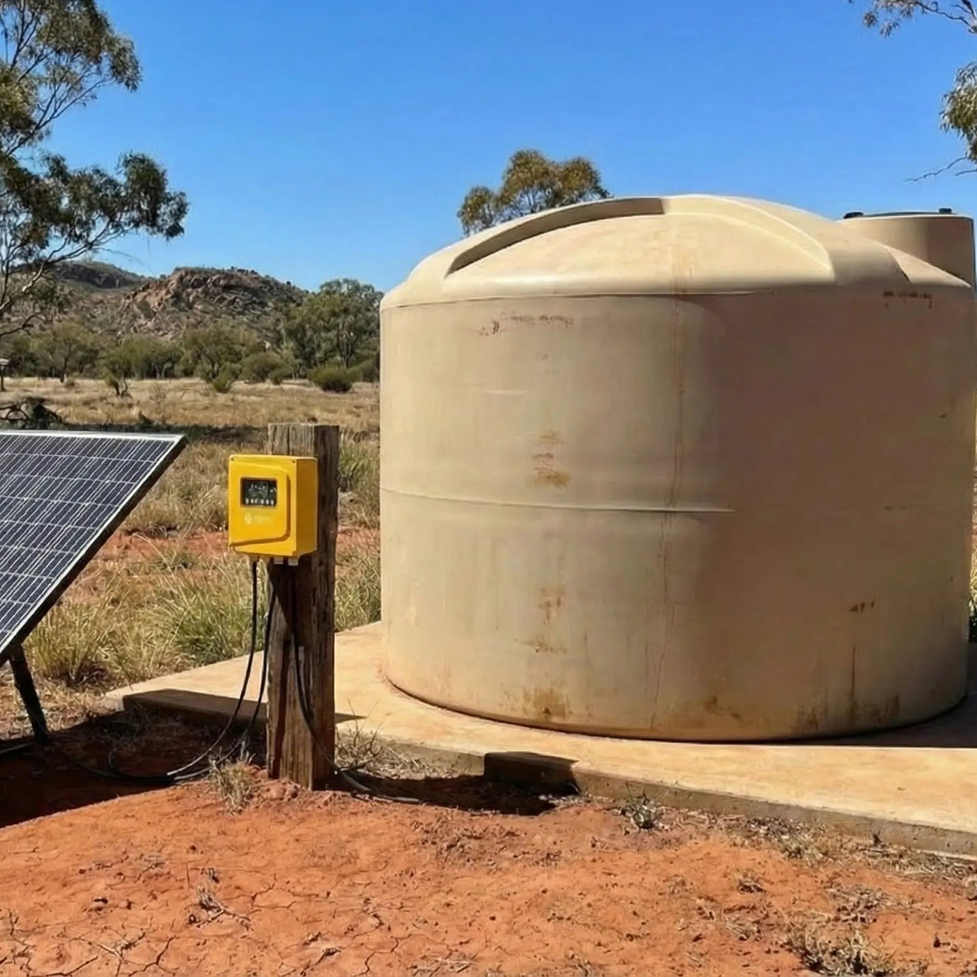 Large beige water tank with a solar panel in an outdoor setting